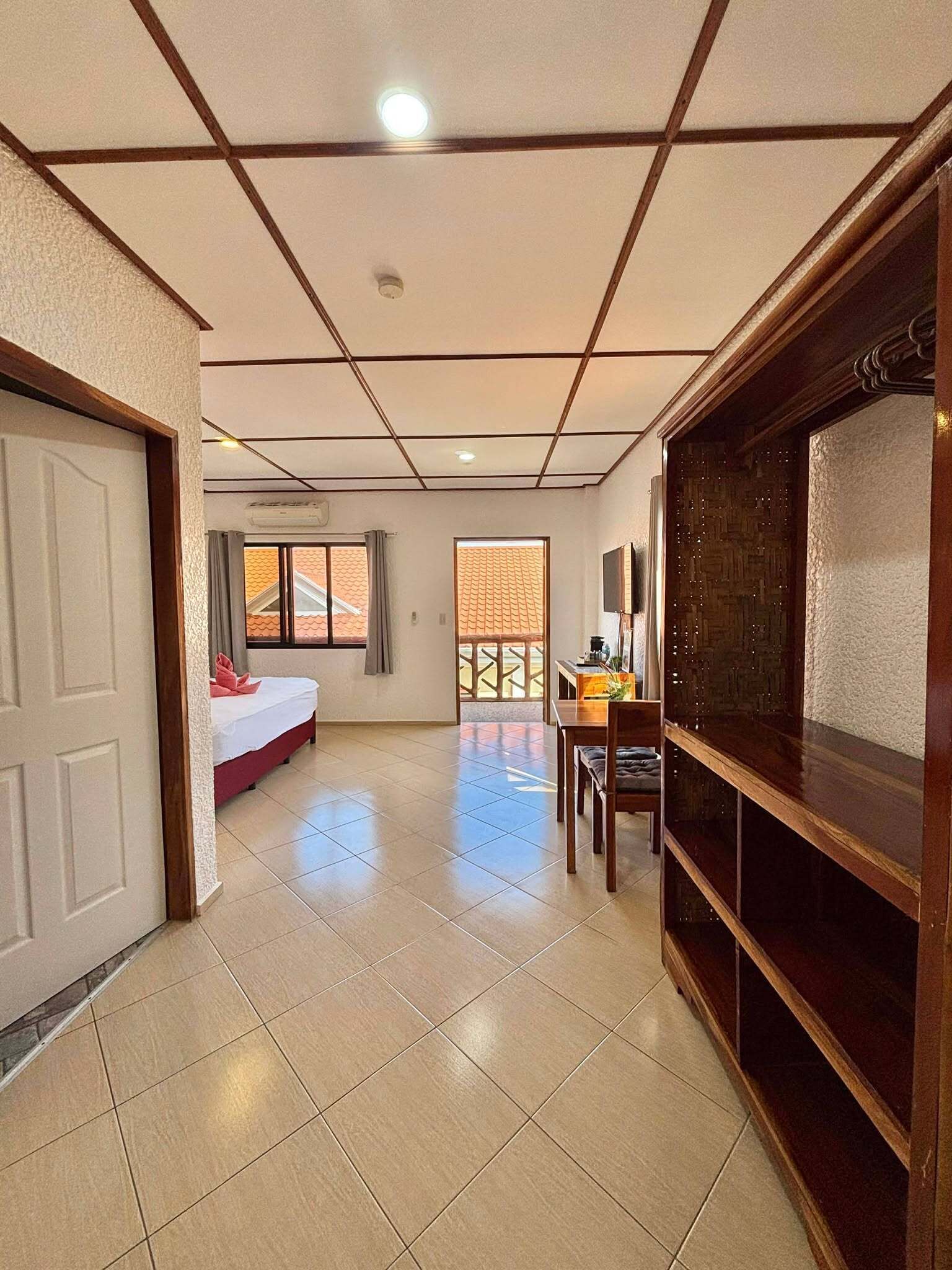 Una habitación de hotel con una cama, un escritorio y un televisor.