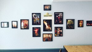A wall with multiple framed pictures, a light fixture, and a wooden table. - The Dorset (Lewes)