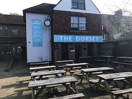 Um edifício com uma placa que diz "THE DORSET" e um relógio acima da entrada.