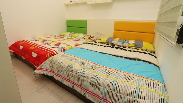 A bedroom with two beds, each with distinct headboards and bedding.