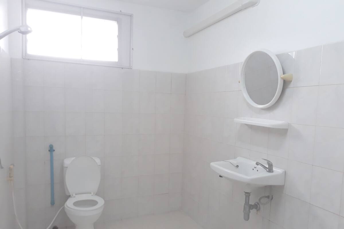 Un baño con inodoro, lavabo y ventana.