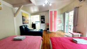 A room with two beds, a sofa, a desk, and a wardrobe. - Rayonghouse Resort (Rayong)