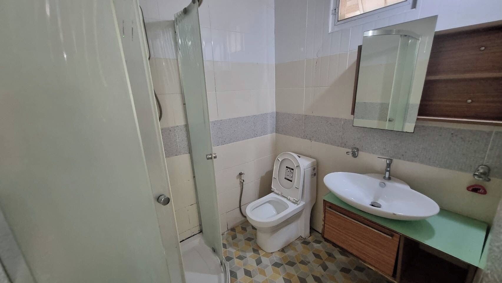 A bathroom with a toilet, sink, and shower.