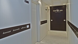 A hotel hallway with a sign reading "Saint Jane Hotels & Suites" and a welcome sign on the wall. - Design Suite Tirano (Tirano)