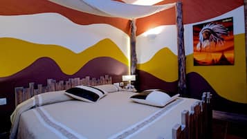 A room with a bed, a nightstand, a lamp, and a poster on the wall.