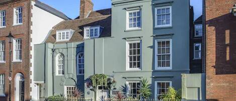A row of traditional terraced houses with a uniform architectural style, featuring symmetrical windows and a consistent facade.