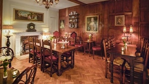 A dining room with wooden furniture, a chandelier, and wall-mounted shelves. - Ye Spotted Dogge (Portsmouth)