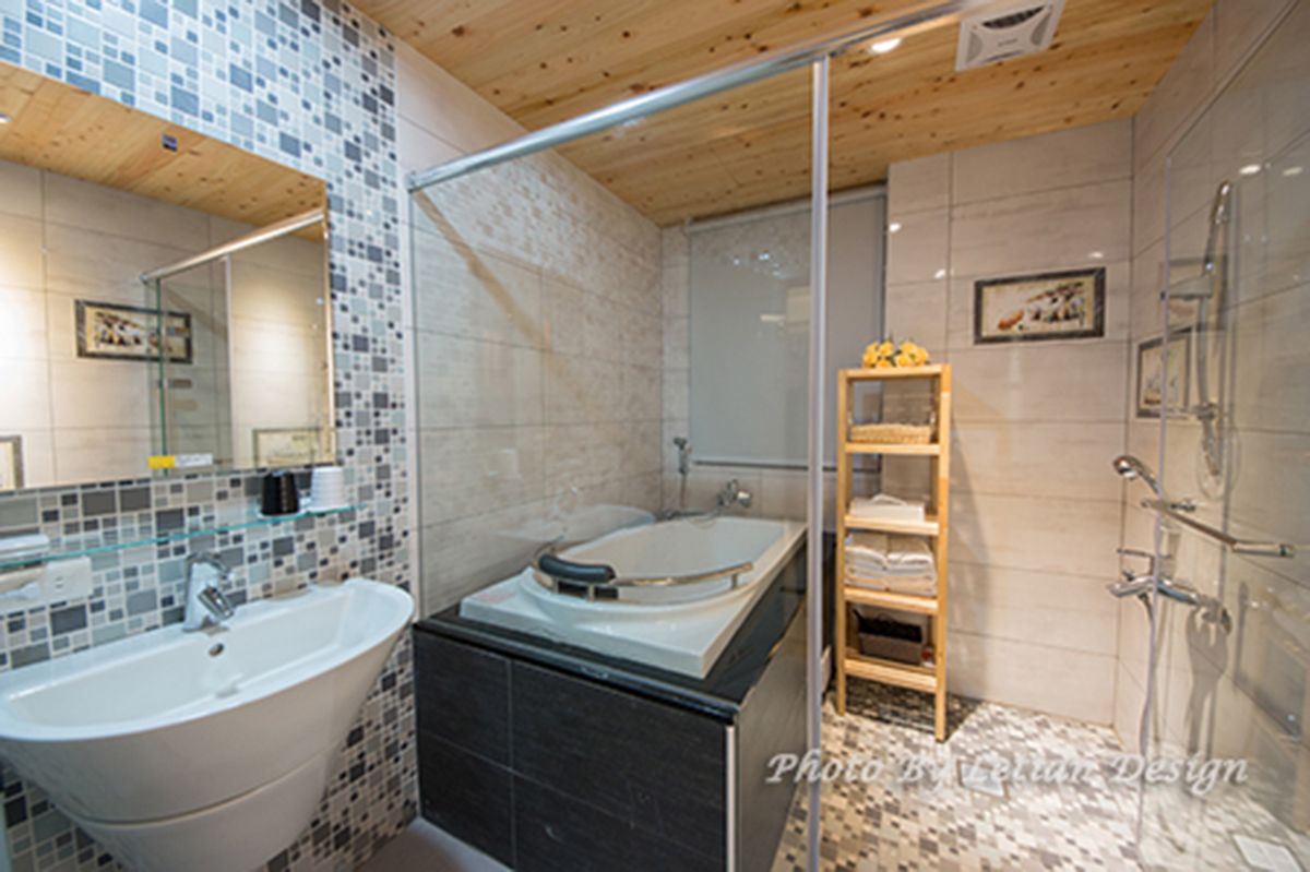 A modern bathroom with a freestanding bathtub, a glass shower enclosure, and a tiled mosaic backsplash.