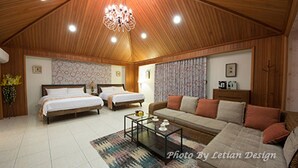 A spacious room with two beds, a sofa, a coffee table, and a chandelier. - Beautiful Mansion B&B (Wujie)