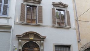 A multi-story building with a central entrance, large windows with shutters, and a stone archway to the right. - Residenza La Musa Amarcord (Florence)