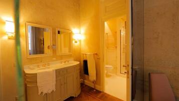 Un bagno con doppio lavabo, uno specchio, un porta asciugamani e una zona doccia.