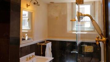 Een badkamer met een douche met glazen wand, een wastafel en een toilet.