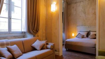 A room with a sofa, a bed, and a wall-mounted light fixture.