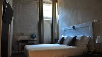 Une chambre à coucher avec un lit, un bureau, un globe terrestre et un téléviseur.