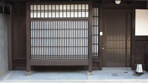 Un bâtiment traditionnel japonais doté d’une porte coulissante et d’un toit recouvert de tuiles.