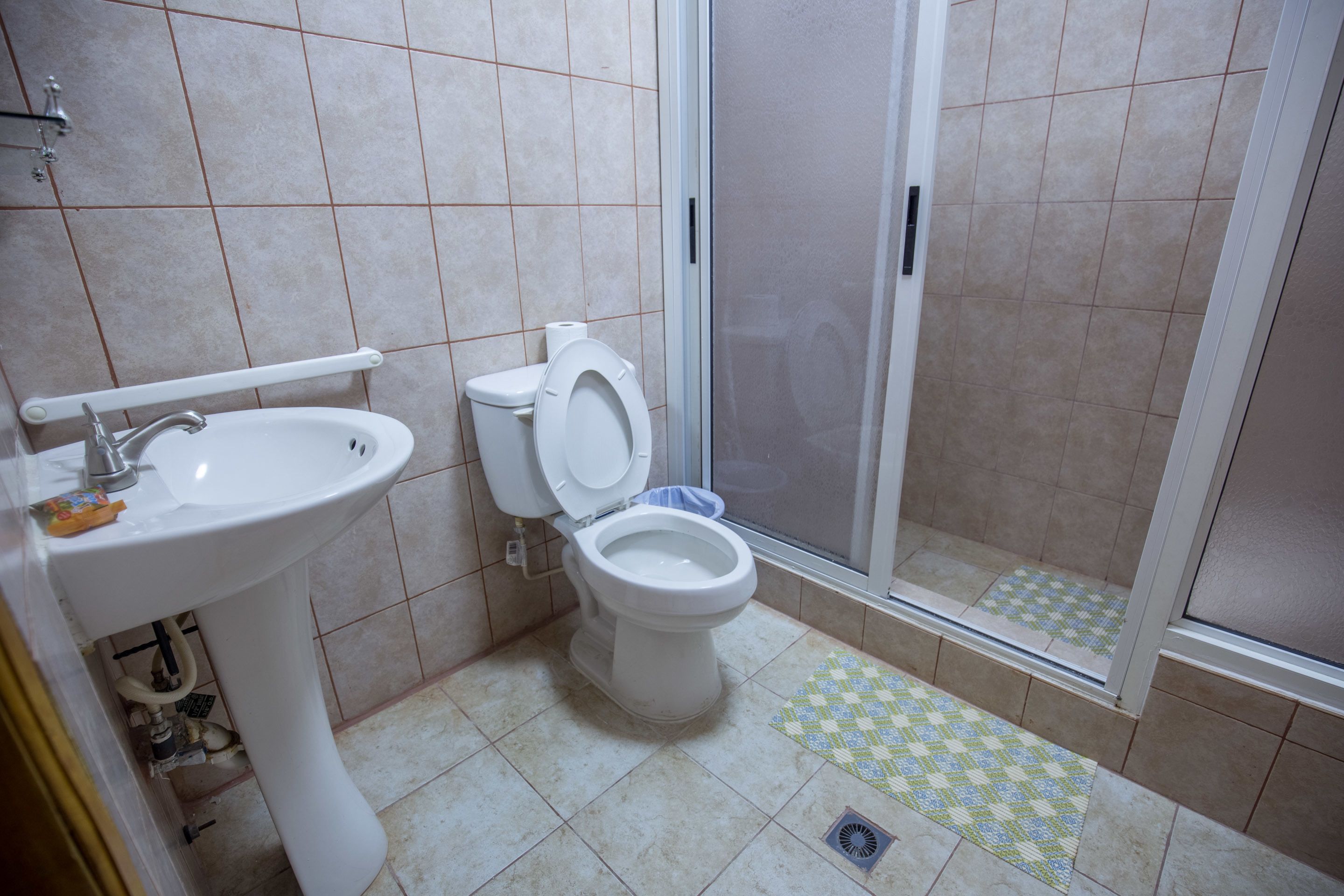 A bathroom with a sink, toilet, and shower.