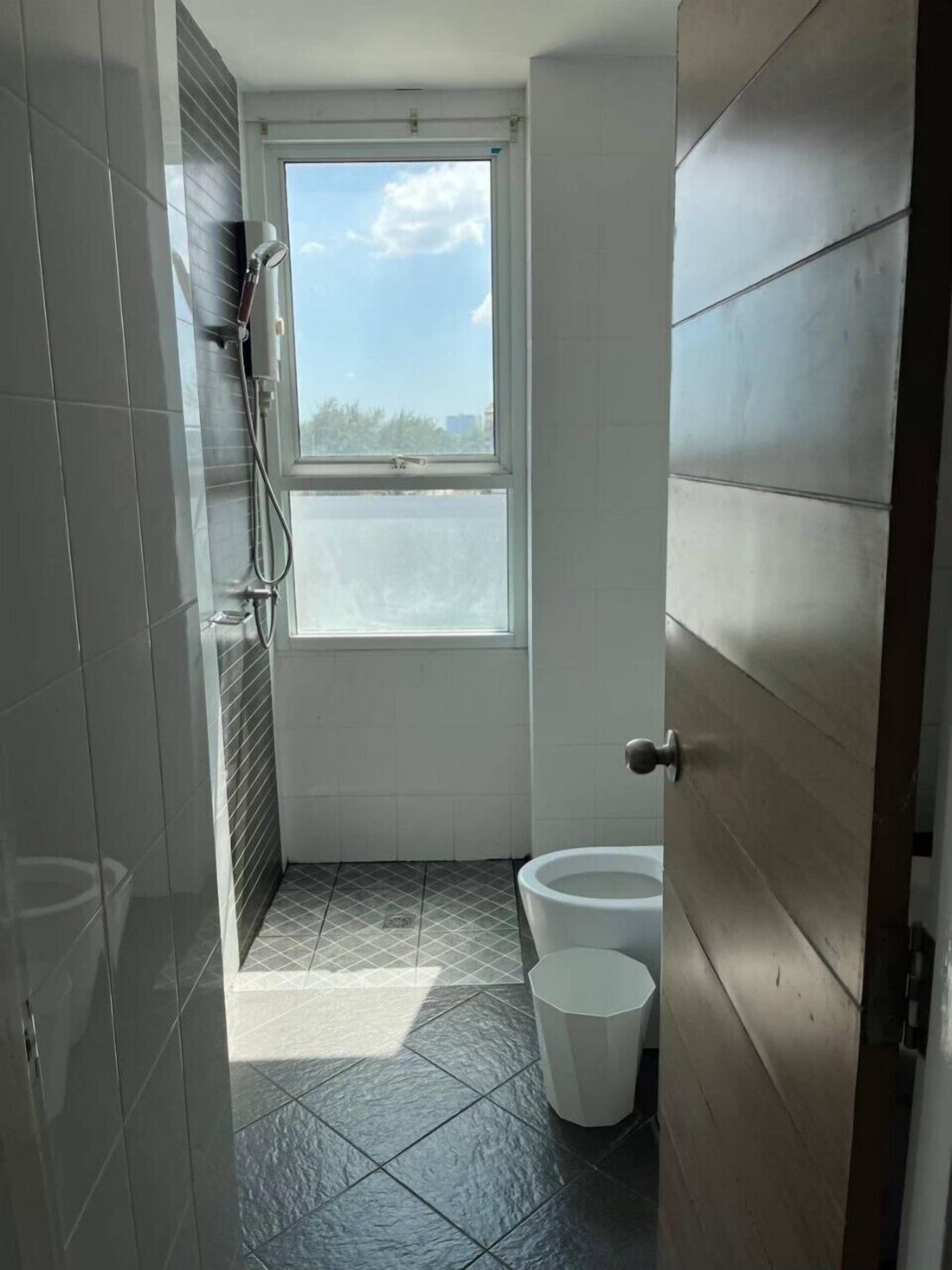 Une petite salle de bain avec douche, toilettes et bidet.