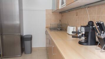 Una cocina moderna con un refrigerador de acero inoxidable, una cafetera y un tostador.