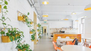 Une cuisine moderne avec des meubles blancs, un îlot central et des chaises orange.