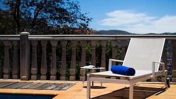 Una piscina al aire libre, sillones reclinables de piscina
