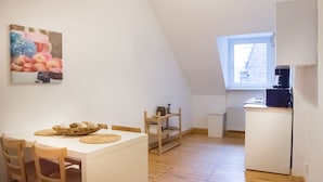 A cozy kitchen with a white refrigerator, a coffee maker, and a window.