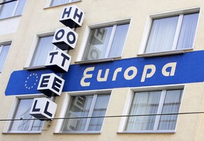 A building facade with the word "Europa" and a European Union flag.