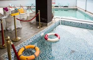 Una piscina techada, sillones reclinables de piscina