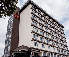 Un edificio de hotel de varios pisos con un diseño arquitectónico moderno, que destaca un cartel con el nombre Gellan Hotel.