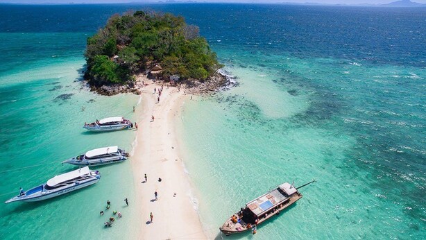 A beach with clear turquoise waters, a small island with dense vegetation, and several boats anchored near the shore. - The Retreat Ao Nang Private Pool Villa (Krabi)