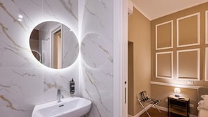 Une salle de bain avec un lavabo en marbre, un miroir et un plancher en bois.