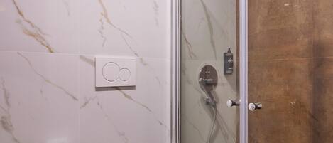 Un baño moderno con ducha acristalada, inodoro y bidé.