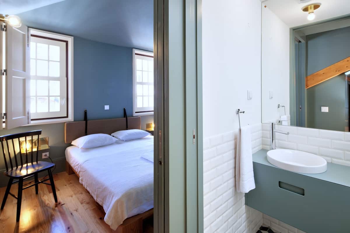 Une chambre à coucher avec un lit, une chaise et une fenêtre.