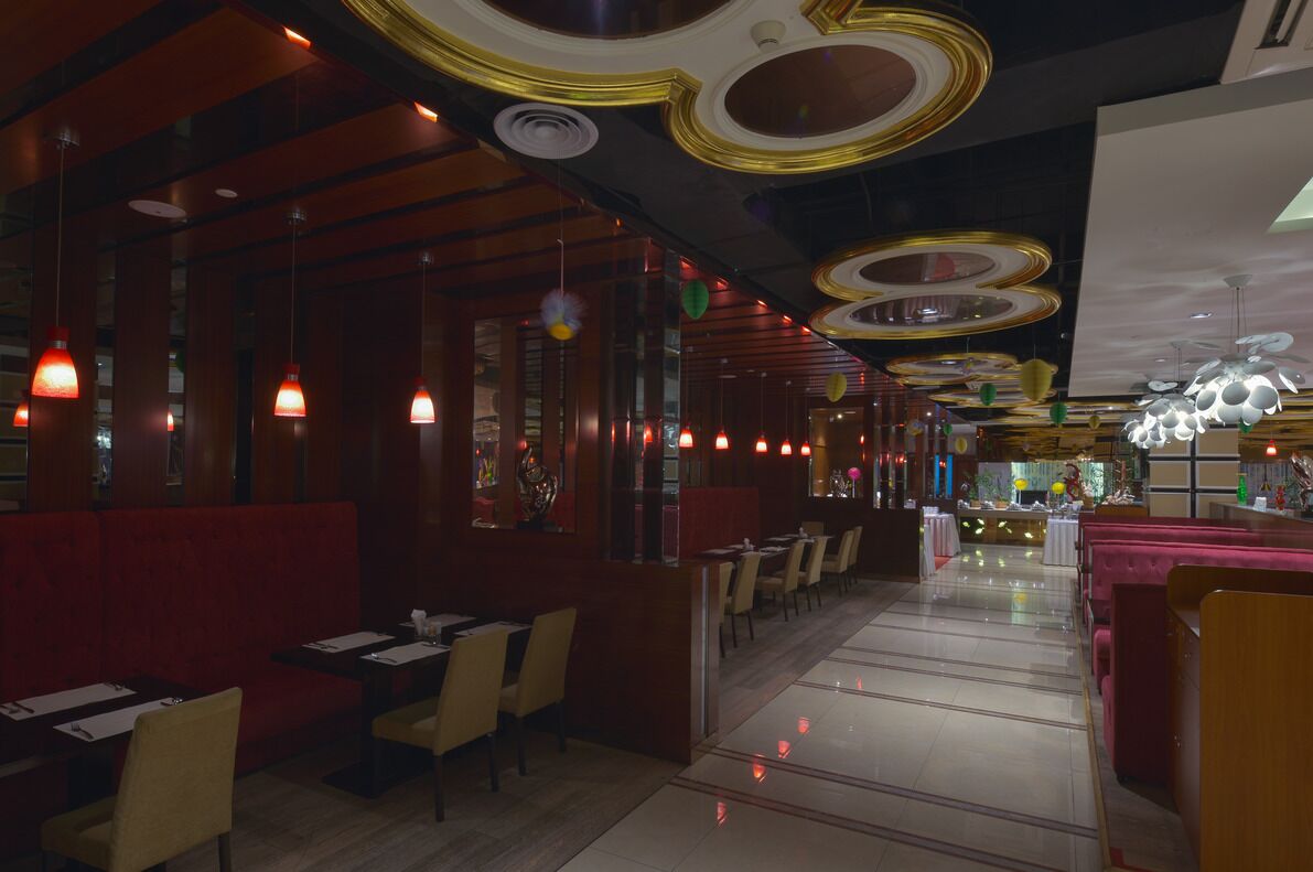 A restaurant interior with booths, tables, and hanging pendant lights.