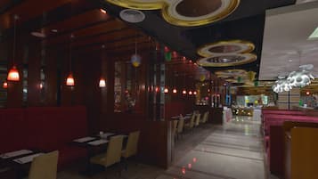 A restaurant interior with booths, tables, and hanging pendant lights.