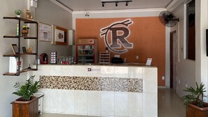 Una zona de recepción con un gran logotipo en forma de 'R', un revoque de azulejos y un mostrador de recepción.
