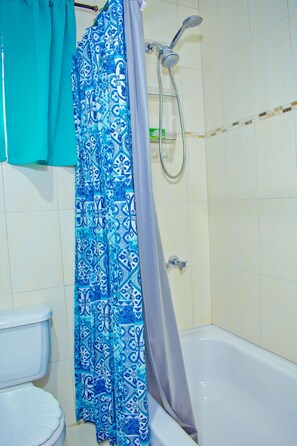 Ein Badezimmer mit Badewanne, Toilette und Duschkabine.