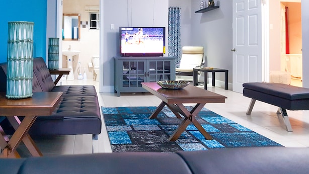 Ein modernes Wohnzimmer mit einer Couch, einem Couchtisch und einem Fernseher.