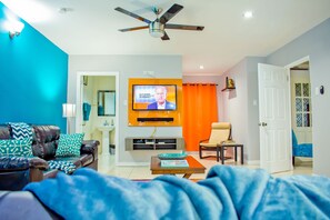 Ein Wohnzimmer mit Fernseher, Sofa und Couchtisch.