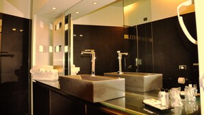 Ein modernes Badezimmer mit einem großen Spiegel, zwei Waschbecken und einer Duschkabine aus Glas.