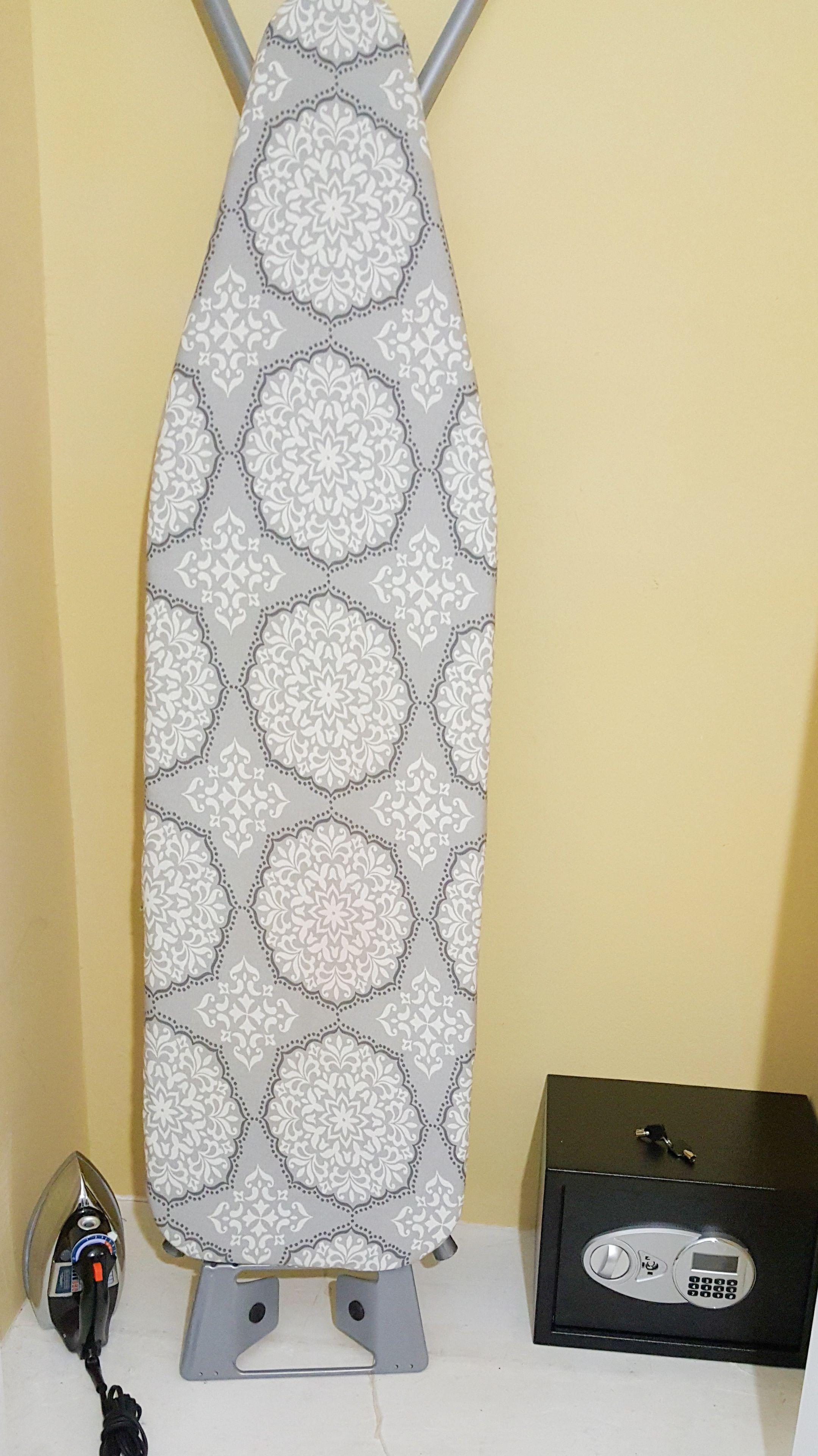 A portable iron with a patterned cloth, a power adapter, and a box with a remote control.