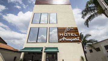 A hotel named 'Hotel Aragari' with a modern facade, large windows, and a green awning.