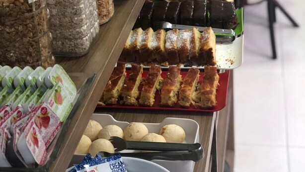 Un buffet proposant une variété de plats, notamment des pâtisseries, des sandwichs et des desserts.