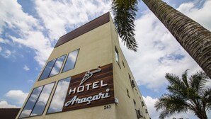 Un hôtel appelé «HÔTEL Anagari», doté d’un design moderne, de grandes fenêtres et du numéro «243» sur sa façade.