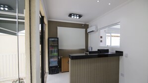 Une cuisine moderne dotée d’un réfrigérateur encastré, d’un meuble en bois et d’un plan de travail noir.