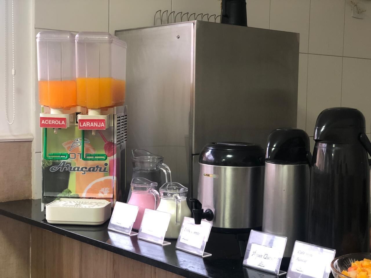 A self-service beverage station with various drink dispensers and a coffee maker.