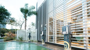 A modern building with a green tiled ground, a metal fence, and a charging station. - ibis budget São Bernardo do Campo (São Bernardo do Campo)