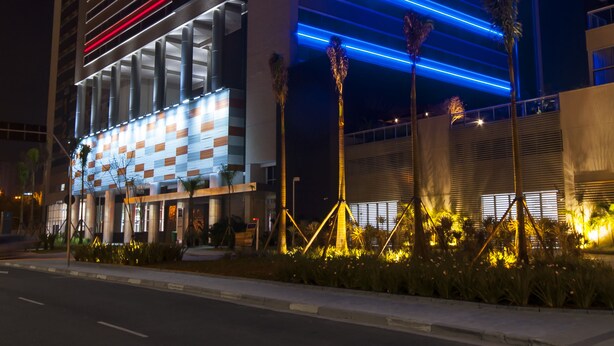 A modern hotel with horizontal lighting accents and a prominent sign. - ibis budget São Bernardo do Campo (São Bernardo do Campo)