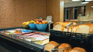 A buffet with various food items including bread, fruits, and pastries. - ibis budget São Bernardo do Campo (São Bernardo do Campo)