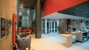 A modern lobby with a reception desk, seating area, and a glass door entrance. - ibis budget São Bernardo do Campo (São Bernardo do Campo)