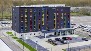 A modern hotel with a unique facade featuring colorful vertical windows. - ibis budget Rotterdam The Hague Airport (Rotterdam)